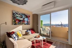a living room with a couch and a window at Magnifique appartement climatisé vue mer in Toulon