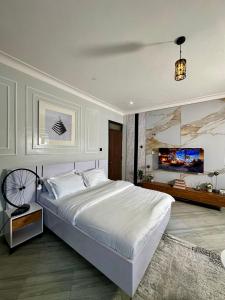 a bedroom with a large white bed and a living room at Suite Nothings in Kampala