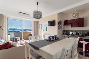 a kitchen and dining room with a white table and chairs at Magnifique appartement climatisé vue mer in Toulon +14 photos