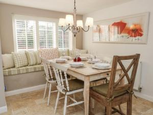 ein Esszimmer mit Tisch und Stühlen in der Unterkunft Curlew Cottage in Plumley Station