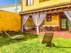 un cortile con due sedie e una casa di Casa Villamor de Orbigo 