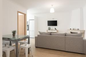 ein Wohnzimmer mit Sofa und Tisch in der Unterkunft Miral Beachside 3 - by HD Properties in Caliços