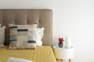 Schlafzimmer mit einem Bett mit einem Kissen und einem Tisch in der Unterkunft Miral Beachside 3 - by HD Properties in Caliços