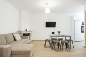 ein Wohnzimmer mit Sofa und Tisch in der Unterkunft Miral Beachside 2 - by HD Properties in Caliços