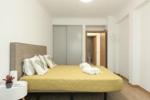 ein Schlafzimmer mit einem Bett mit Handtüchern darauf in der Unterkunft Miral Beachside 2 - by HD Properties in Caliços