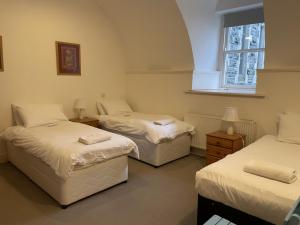 een kamer met drie bedden en een raam bij Moat House 1 in Fort Augustus +10 foto's