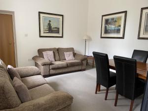 een woonkamer met een bank en een tafel bij Moat House 1 in Fort Augustus