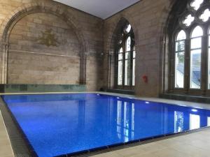 a large swimming pool with blue water in a building at Moat House 1 in Fort Augustus
