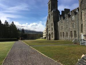 een groot stenen gebouw met een grasveld bij Moat House 1 in Fort Augustus