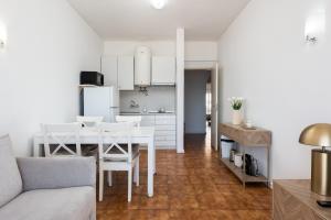 eine Küche und ein Esszimmer mit einem weißen Tisch und Stühlen in der Unterkunft Maresia - Front beach - Quarteira in Vilamoura + 19 Fotos