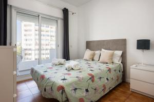 ein Schlafzimmer mit einem Bett mit zwei Stofftieren darauf in der Unterkunft Maresia - Front beach - Quarteira in Vilamoura