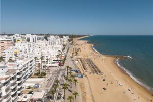 eine Luftaufnahme eines Strandes mit Gebäuden und dem Meer in der Unterkunft Maresia - Front beach - Quarteira in Vilamoura