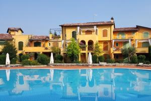 a hotel with a swimming pool in front of a building at Borgo del Torchio C8 ByBookinggardalake in Manerba del Garda
