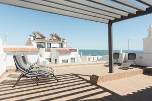 eine Terrasse mit Stühlen und Meerblick in der Unterkunft Miral Beachside 4 - by HD Properties in Caliços