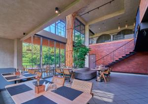 a restaurant with tables and chairs and a staircase at The Saray Munnar by VOYE HOMES in Anachal
