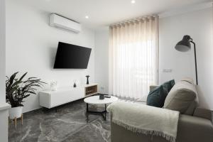 a white living room with a couch and a table at Espadarte - Sea view by HD in Quarteira