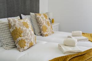 a white bed with pillows and towels on it at Espadarte - Sea view by HD in Quarteira +56 photos