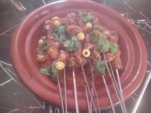 une assiette rouge de nourriture avec des haricots et des oignons verts dans l'établissement Auberge Tafouyt, à Tamtetoucht