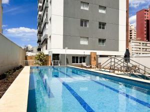 a large swimming pool in front of a building at AP Smart Quirino in Campinas