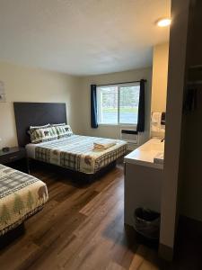a bedroom with two beds and a window at Winthrop Inn in Winthrop