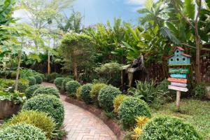 un jardín con un sendero de ladrillos y una casita para pájaros en Indochine Hotel Hoi An, en An Bàn (2)