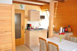 a kitchen with a table with a vase of flowers on it at Ferienwohnung Neubert in Wolkenstein
