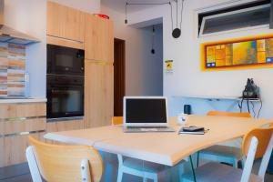 un ordenador portátil sentado en una mesa en una cocina en Tortolì Old Town, en Tortolì