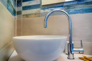 Un lavabo blanco con grifo en un baño. en Tortolì Old Town, en Tortolì