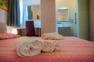 a bed with rolled towels on top of it at Tortolì Old Town in Tortolì +51 photos