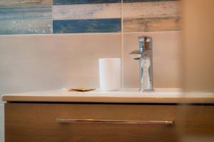 a sink with a roll of toilet paper on a counter at Tortolì Old Town in Tortolì