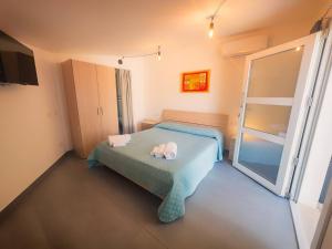a bedroom with a bed with two towels on it at Tortolì Old Town in Tortolì