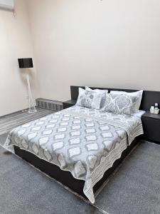 a bedroom with a large bed and a lamp at Lider Hotel Tashkent in Muruntau