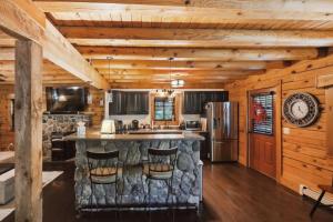 eine Küche mit einer Bar in einem Blockhaus in der Unterkunft Cushing Home - Family Cabin Near Wachusett Mtn home in Ashburnham