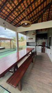 un grande tavolo in legno in una stanza con cucina di Chalés do Atlântico a Salinópolis