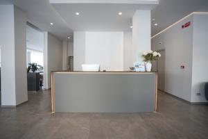 Un gran mostrador blanco en una oficina con flores encima. en Hotel Seaview, en Rímini