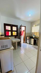 eine Küche mit weißem Fliesenboden in der Unterkunft Casa em condominio proximo ao beach park in Aquiraz