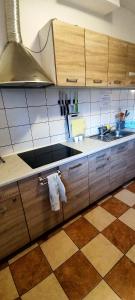 eine Küche mit Holzschränken und Fliesenboden in der Unterkunft Pokoje Gościnne VEIKSME in Bestwina