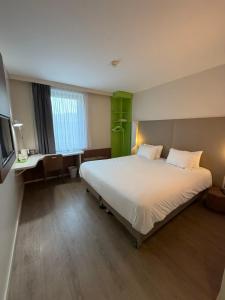a hotel room with a large bed and a desk at Campanile Annemasse Gare– Genève in Annemasse