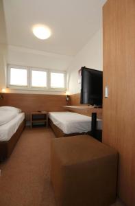 a hotel room with two beds and a flat screen tv at Apartment Hotel am Sand in Hamburg