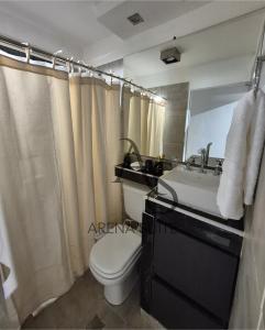 Un baño con inodoro, lavabo y espejo. en Arena Suite LR, en La Rioja