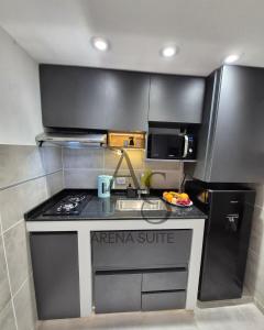 a small kitchen with a stove and a microwave at Arena Suite LR in La Rioja +3 photos