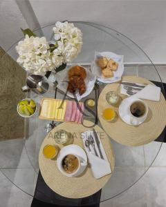 una mesa de cristal con un plato de comida y un jarrón de flores en Arena Suite LR, en La Rioja