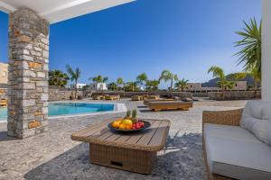 un bol de fruta en una mesa junto a una piscina en Amani Villas Lindos, en Lindos
