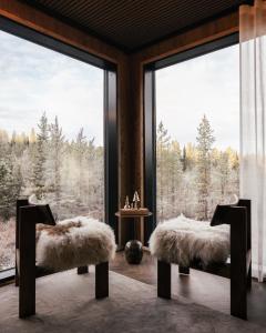 a room with a large window with two chairs and a table at SkyView Igloo Resort in Rovaniemi
