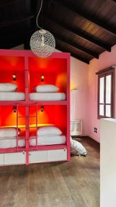 a room with a red bunk bed with white mattresses at Pink Mango Hostel in Athens +32 photos