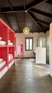 a large room with red shelves and a white refrigerator at Pink Mango Hostel in Athens