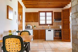 a kitchen with wooden cabinets and a table with chairs at Ferienhaus In Polis Chrysochous Mit Offenem Kamin in Polis Chrysochous