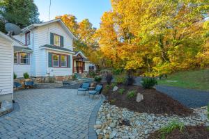 a yard with a house and a patio with chairs at 1910 Asheville Gem in Fairview