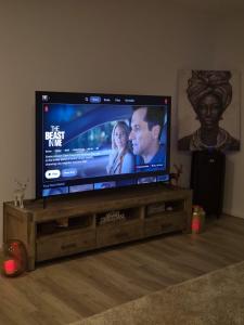 a flat screen tv sitting on a wooden entertainment center at Cosy Home in Melton South in Melton South