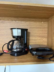 a black blender sitting on top of a wooden shelf at Hotel Imperial Flat in João Pessoa